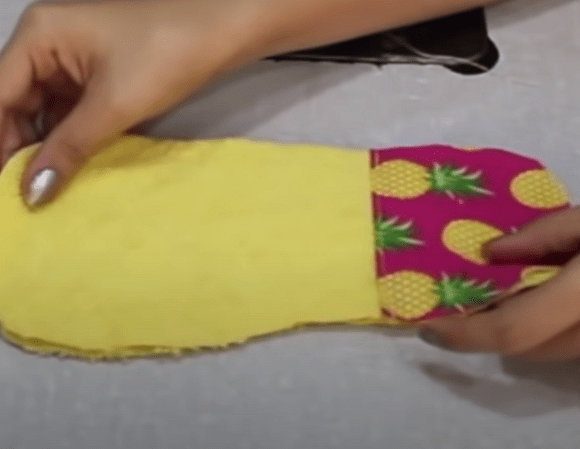 Slipper sole layers and heel reinforcement being stitched