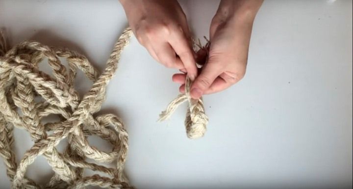 Скрепленный конец джутовой косы в руках
