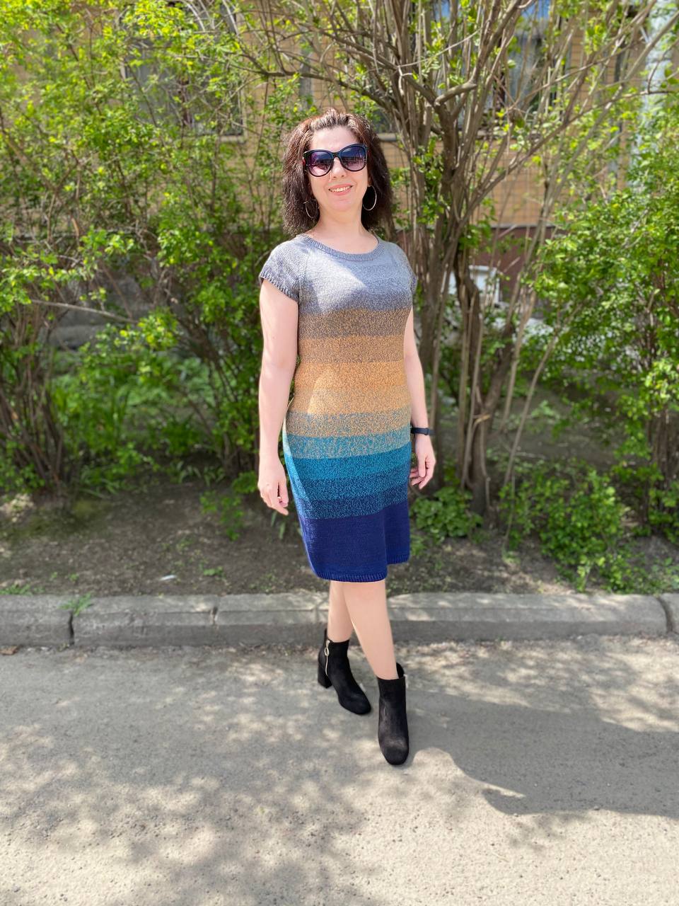 A woman in a striped knitted dress outdoors