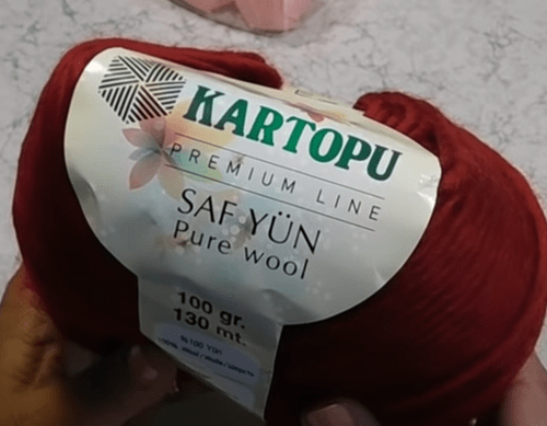 A red skein of Kartopu Saf Yün for a medium-weight hat