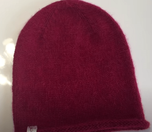 A simple red hat in stockinette stitch, no cuff