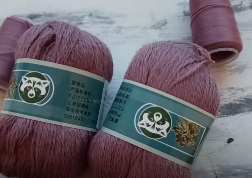 Skeins of fluffy yarn and spool thread for knitting a hat