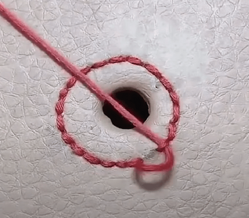Small burn hole stitched around with backstitch
