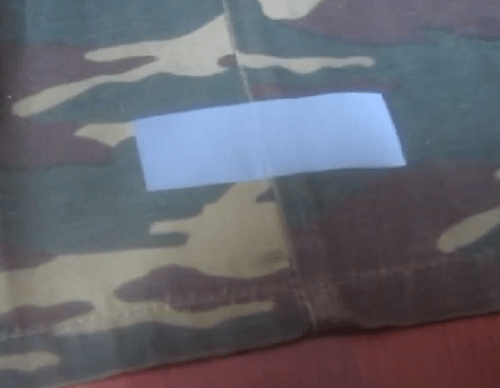 Reflective tape covering a hole in jacket fabric