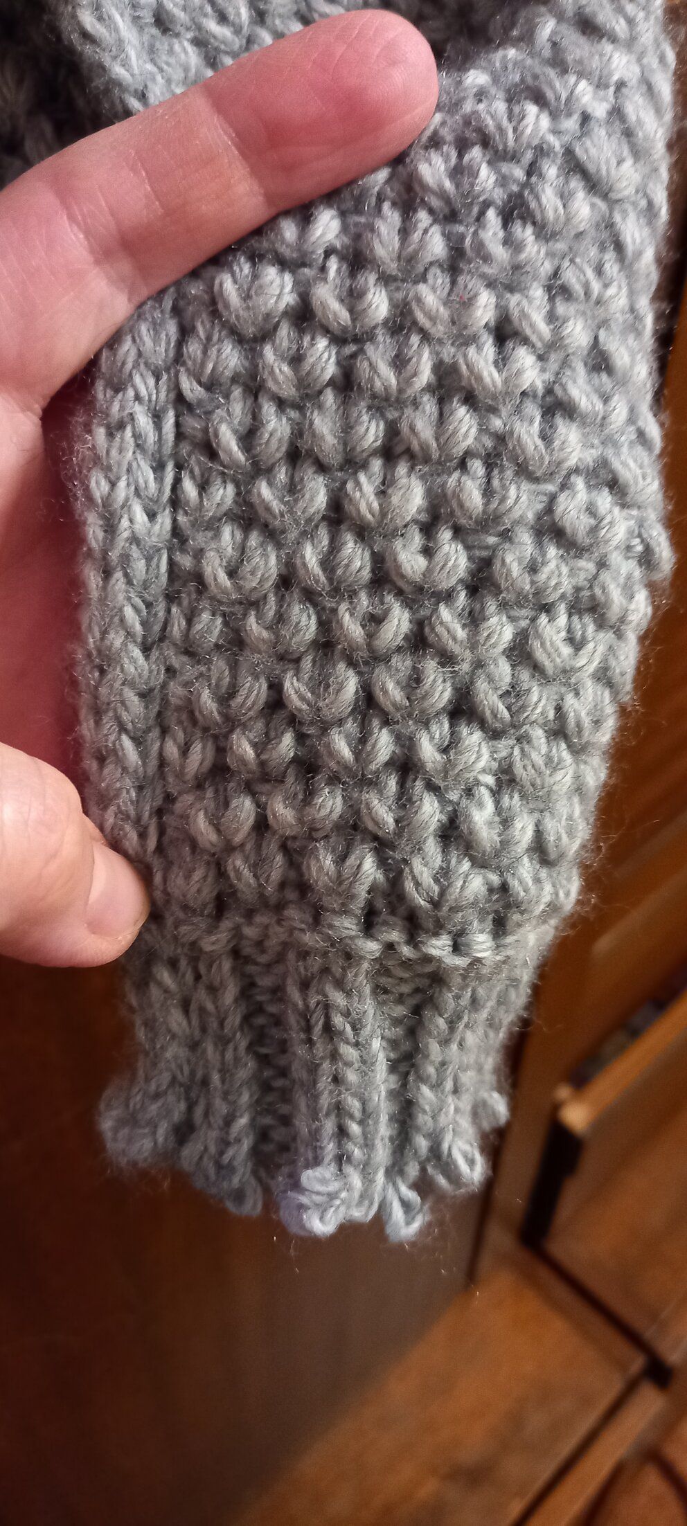 Close-up of a grey knitted pattern on a scarf or cowl