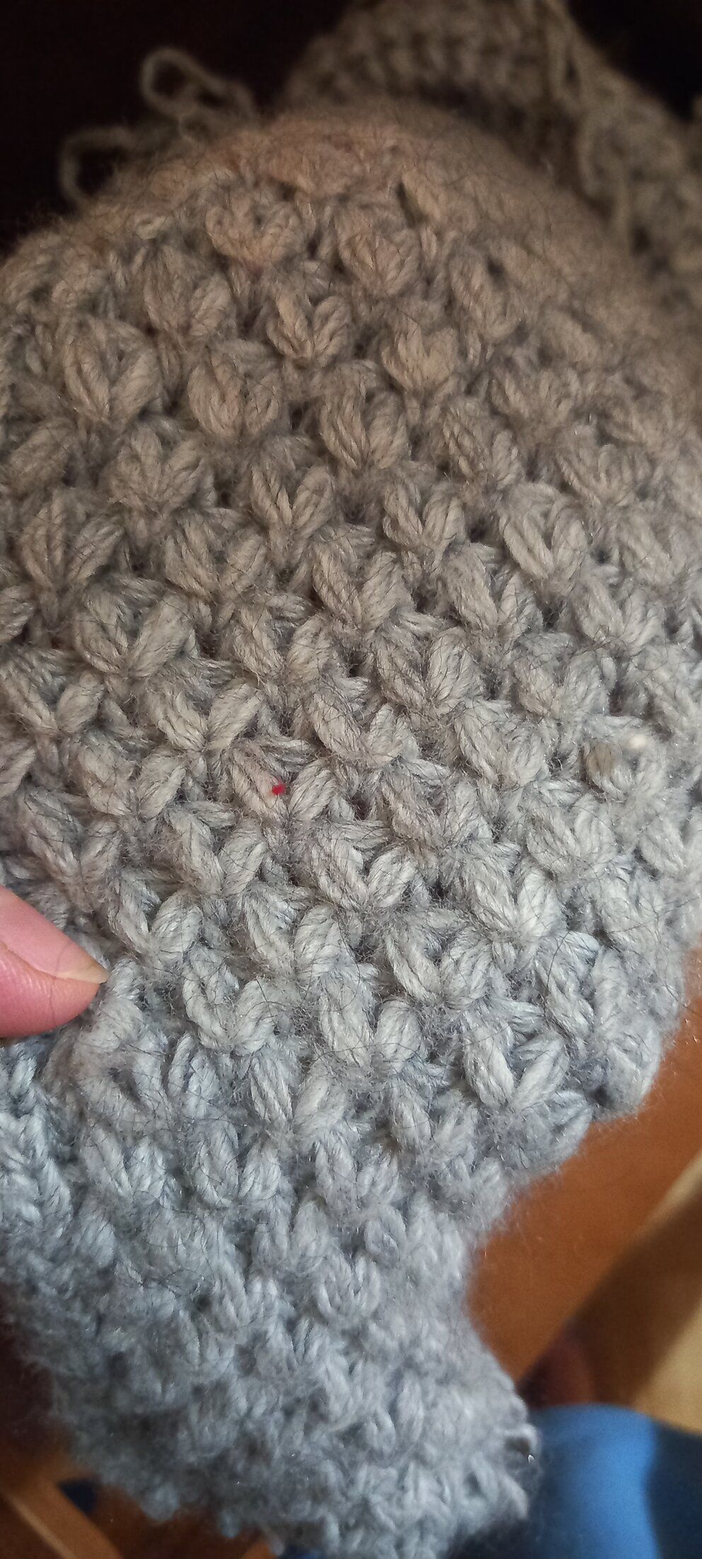 Stretched section of grey knitted fabric with a voluminous pattern