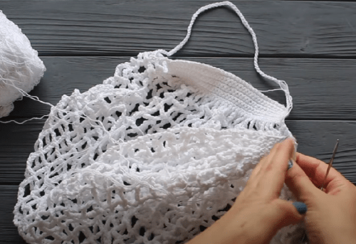 Joining the two halves of the crochet market bag and gathering the sides