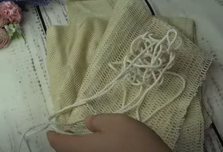 Threading a cord into the drawstring casing of a reusable produce bag