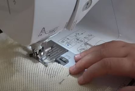 Sewing the edge of a mesh produce bag on a sewing machine