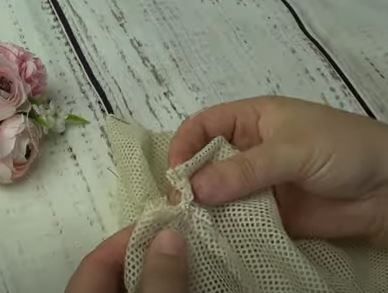 Threading a cord through the casing of a mesh produce bag