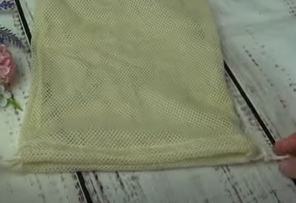 Pulling the cord in the top casing of a reusable produce bag