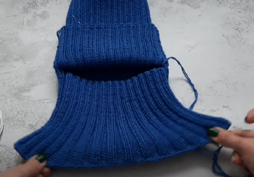 The finished lower snood section of a blue helmet hat