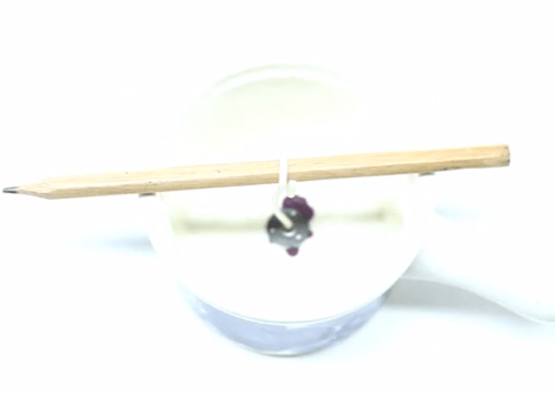 Cotton wick centered in a small translucent mold and held upright with a wooden stick