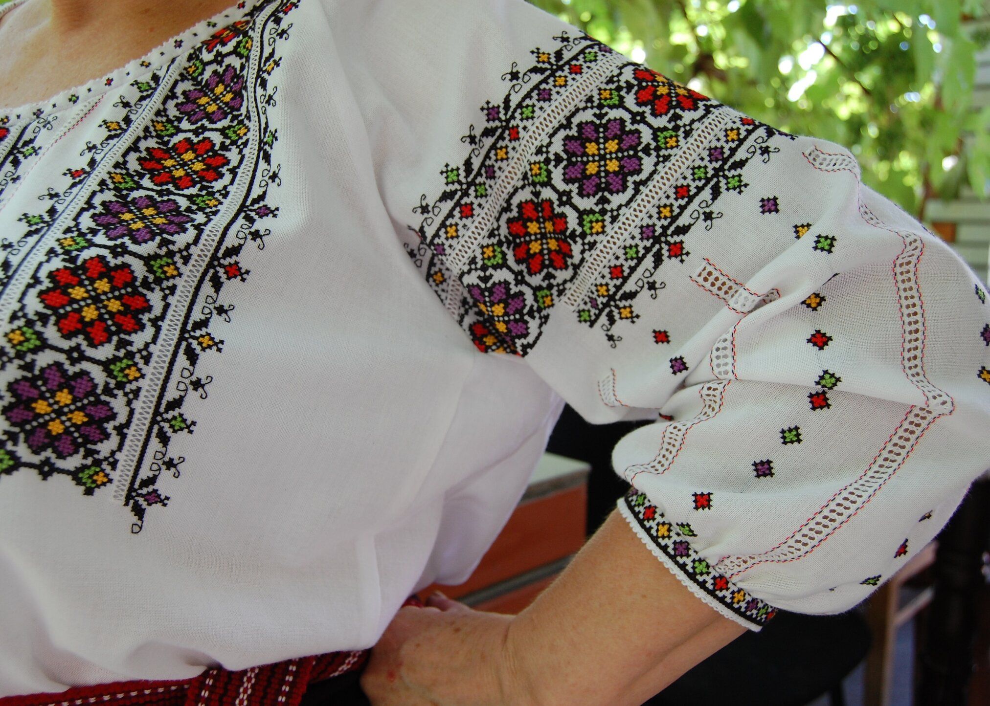 Fragment of a white vyshyvanka with floral embroidery on the sleeve and chest