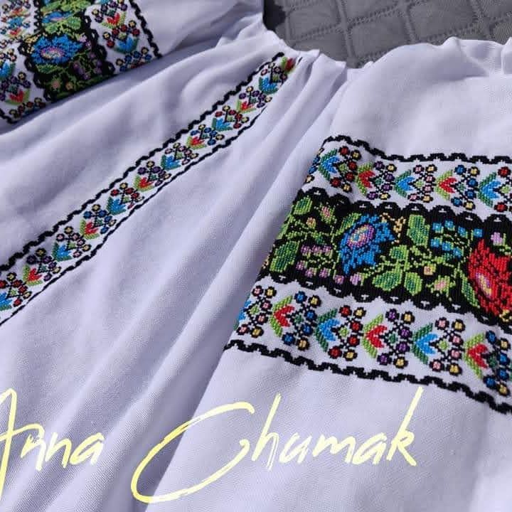 Fragment of a white vyshyvanka with floral embroidery and black ornament