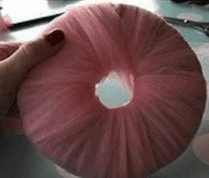 Pink tulle tightly wrapped around a cardboard ring