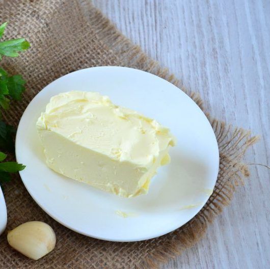 Block of butter with peeled garlic and parsley