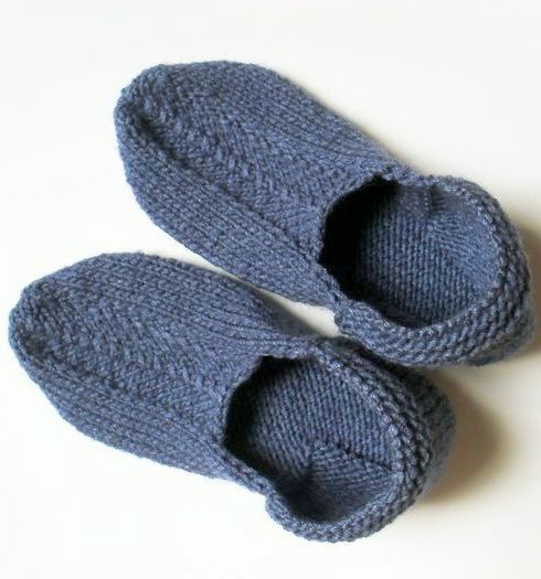 A pair of gray knitted slippers on two needles
