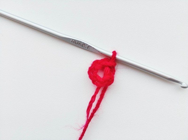 Starting ring of red yarn on a crochet hook
