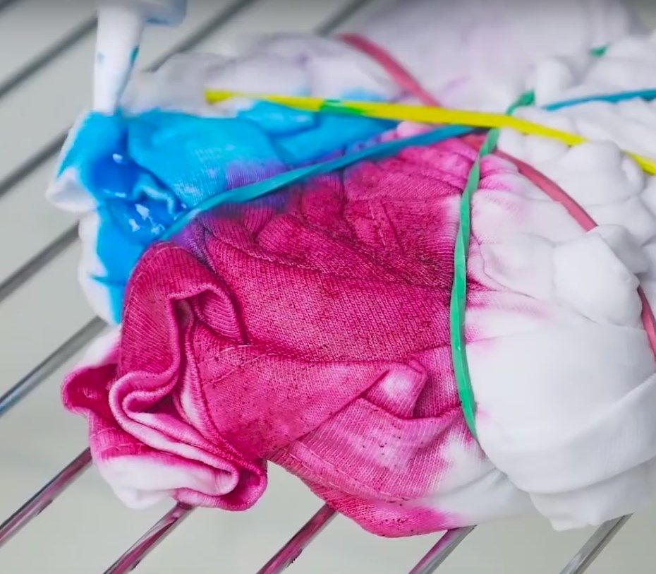 Close-up of pink and blue dye soaking into the bundled T-shirt