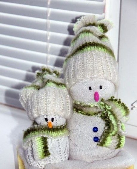 Two sock snowmen wearing knitted hats and scarves
