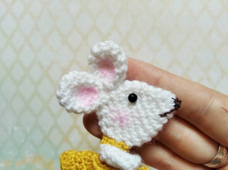 Finished crocheted mouse brooch in hand