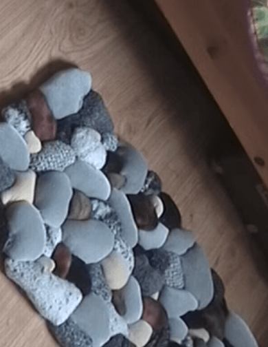 Finished fabric rug shaped like sea pebbles