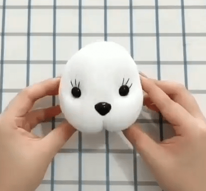 White sock toy face with eyes and a black nose