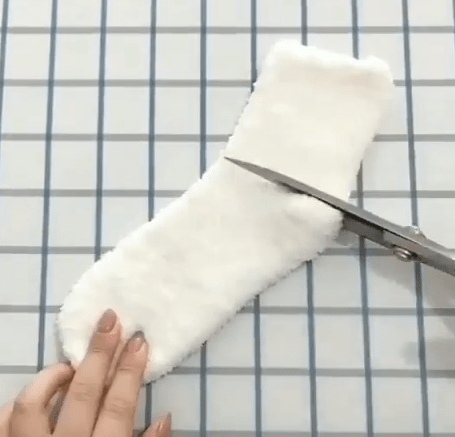 Cutting a fluffy white sock below the heel