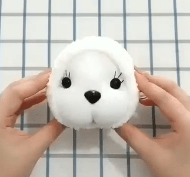 Bunny head made from a white sock with sewn-on eyes and nose