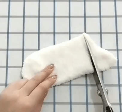White sock being cut with scissors for toy pieces