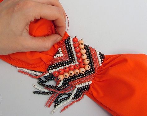 Trying on the beaded embellishment on the orange swimsuit top