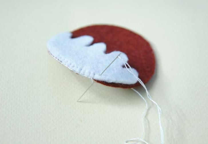 Sewing white icing onto a pudding piece