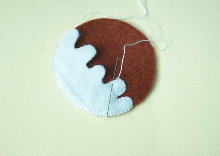 Sewing together the halves of a pudding ornament