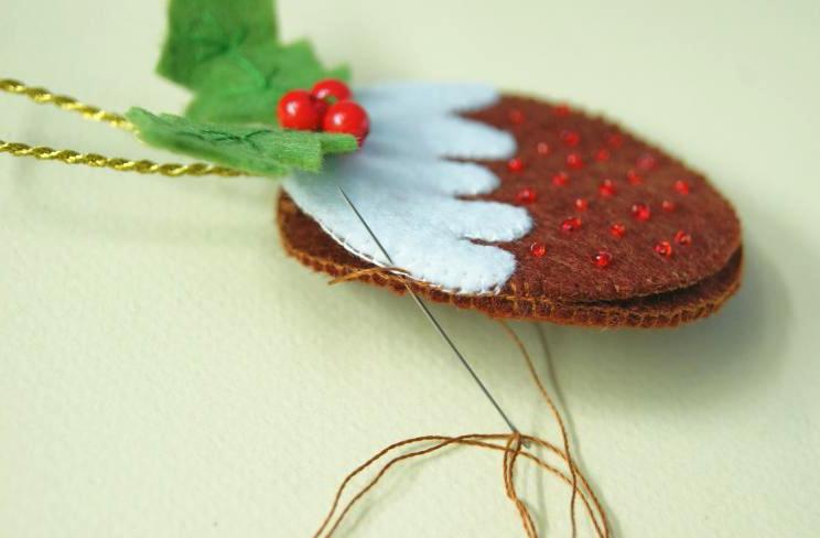 Hand-sewing the pieces of a pudding ornament