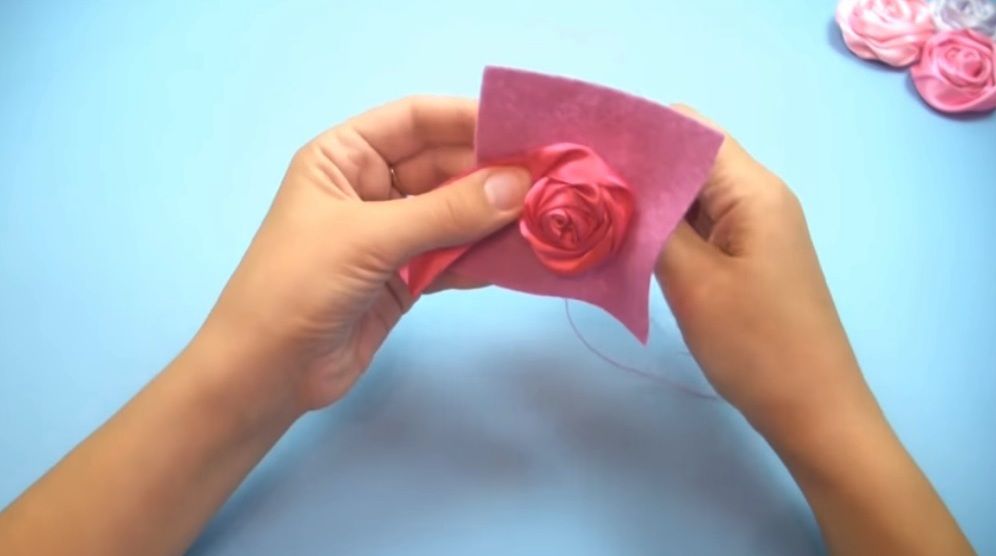 Satin ribbon rose with several completed petals