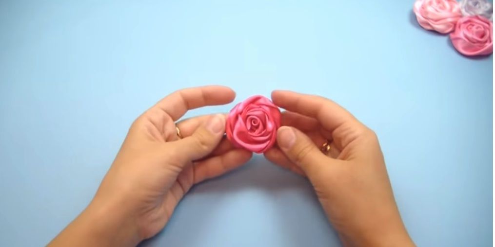 Satin ribbon rose held in a crafter's hands
