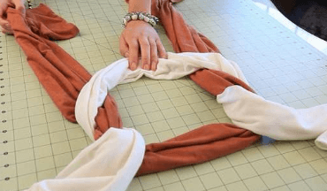 Threading one folded strip under another during weaving