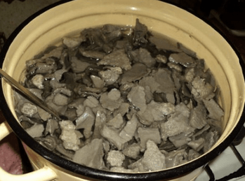 Мокрая серая бумажная масса в большой эмалированной кастрюле