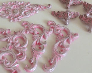 Painted decor pieces with a pink base and white highlights