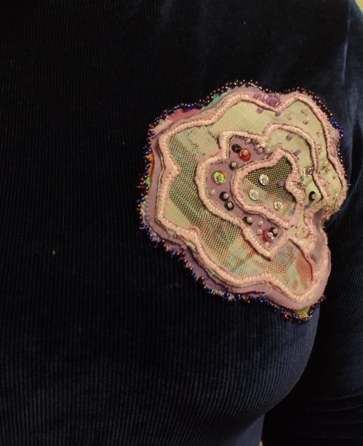 A plain turtleneck decorated with a floral appliqué