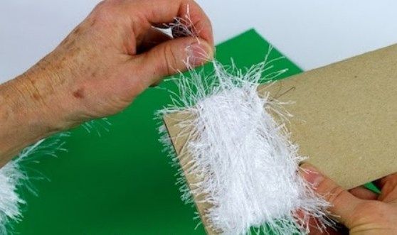 White yarn wrapped around cardboard for the elf's beard