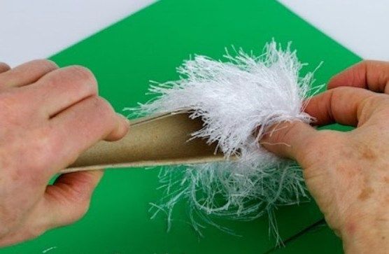Removing the yarn from the cardboard for the toy elf's beard