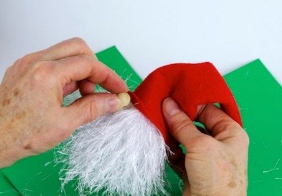 Gluing the bead nose under the brim of the elf's hat