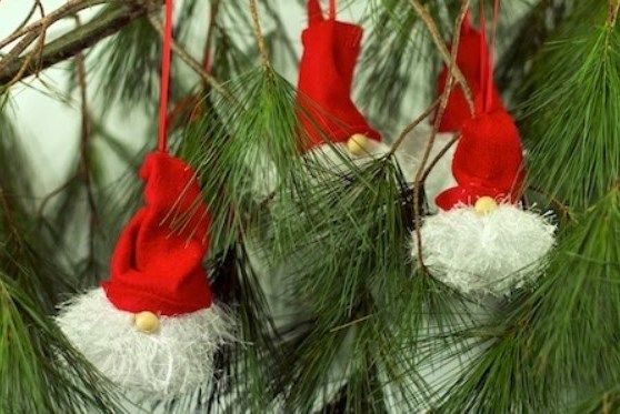 Finished elf ornaments with red hats on a branch