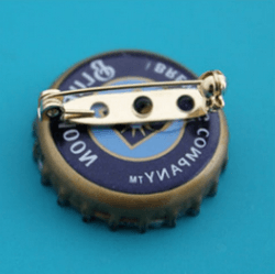 Back side of a bottle cap brooch with a pin