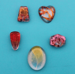 Finished resin jewelry on a light blue background