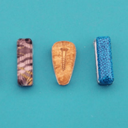 Three oblong resin blanks on a light blue background