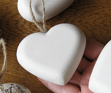 White heart-shaped decorative stones with hanging cords
