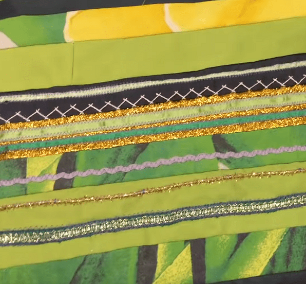 Fabric strips, trim, and decorative stitching on a green base